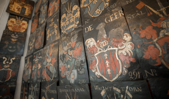 Wall of the ceremonial hall in Stockholm's House of Nobility (Riddarhuset), covered with the coats of arms of noble families, including the de Geer family © J. Van Belle – WBI